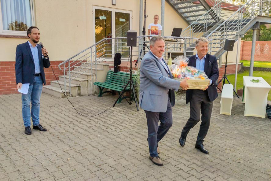 Geschäftsführung übergibt einen großen Präsentkorb an die Abteilung Innere Medizin.