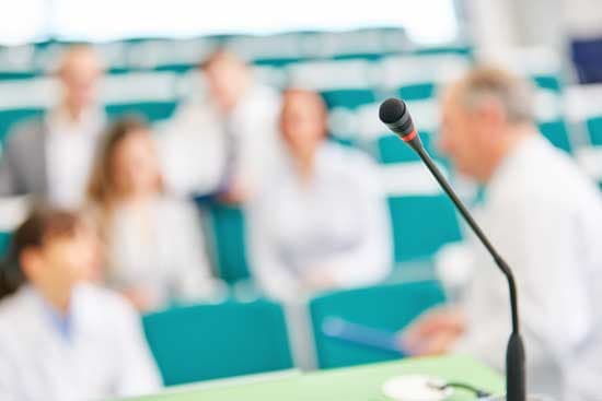 Mikrofon im Hörsaal bei medizinischer Fortbildung – Ärztinnen und Ärzte im Austausch während einer klinischen Weiterbildung.