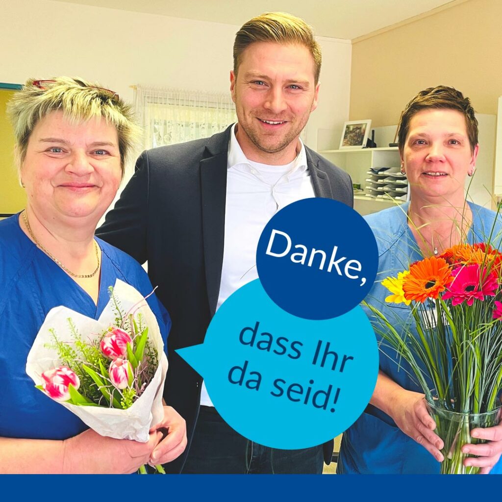 Im Bild sieht man die Geschäftsleitung unseres Krankenhauses, der Blumen für die Frauen zum Weltfrauentag verschenkt hat. Im Text steht: Danke, dass Ihr da seid!
