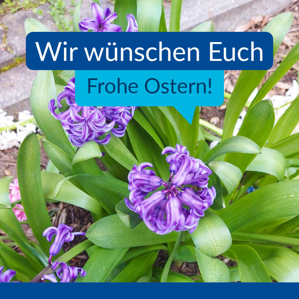 Im Bild sieht man eine Blume. Im Text steht: "Wir wünschen Euch Frohe Ostern!"